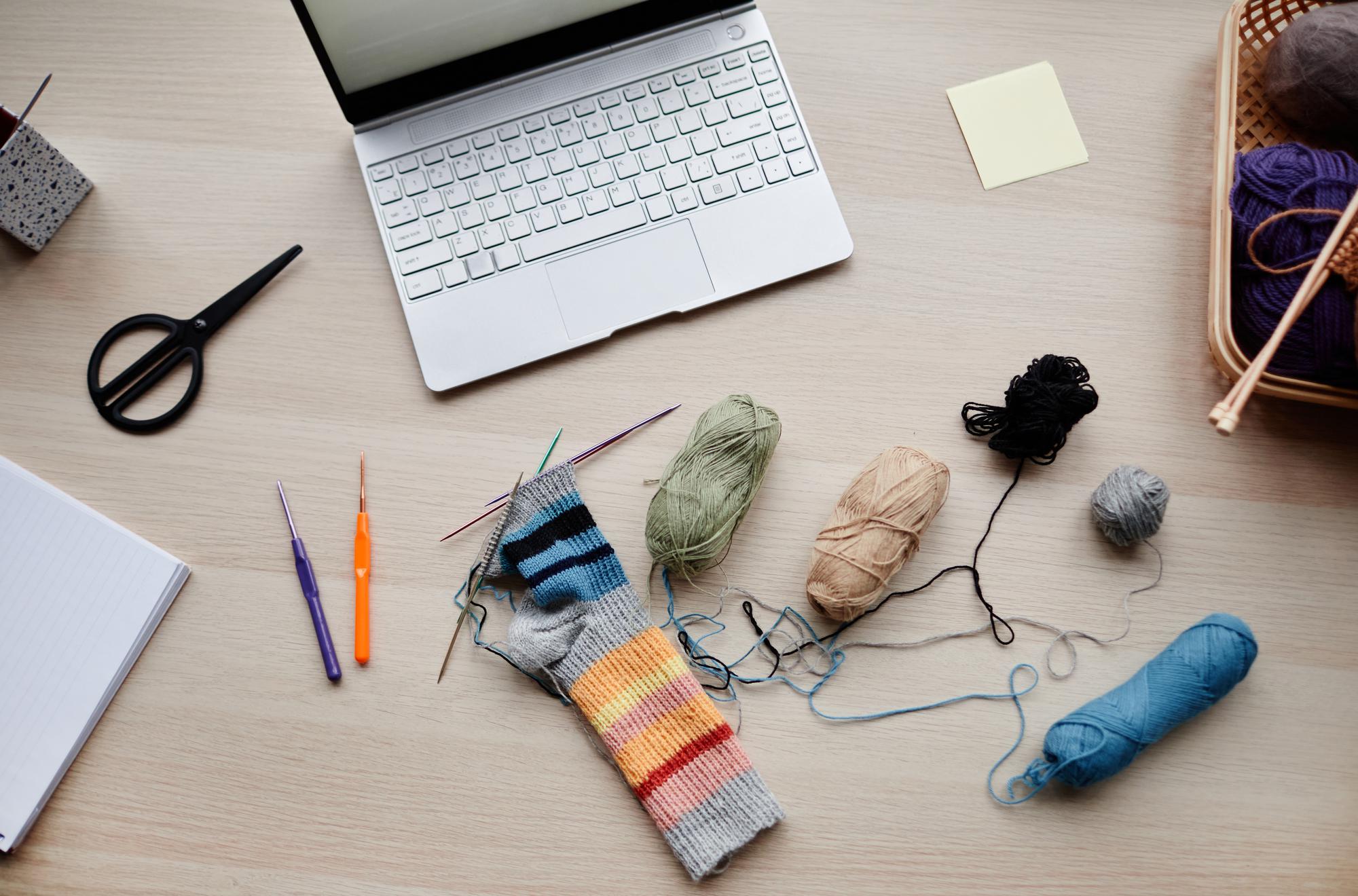Workspace with threads and embroidered samplers on a table